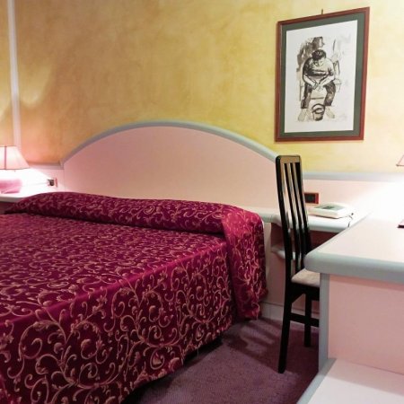 Camera con letto e copriletto rosso decorato.