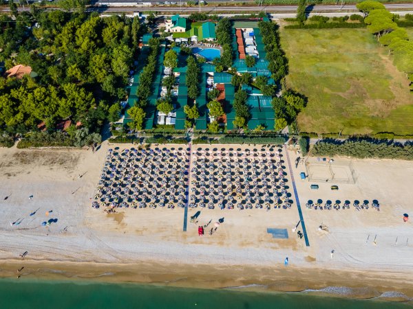 Spiaggia affollata con ombrelloni e vista dall'alto.