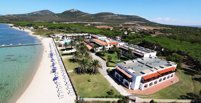 Vista aerea di un resort sul mare con spiaggia.