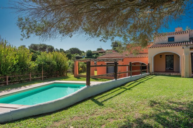 Piscina in giardino con casa arancione.