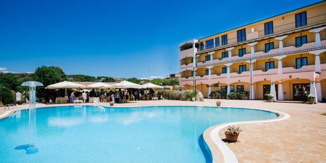 Piscina con hotel e ombrelloni.
