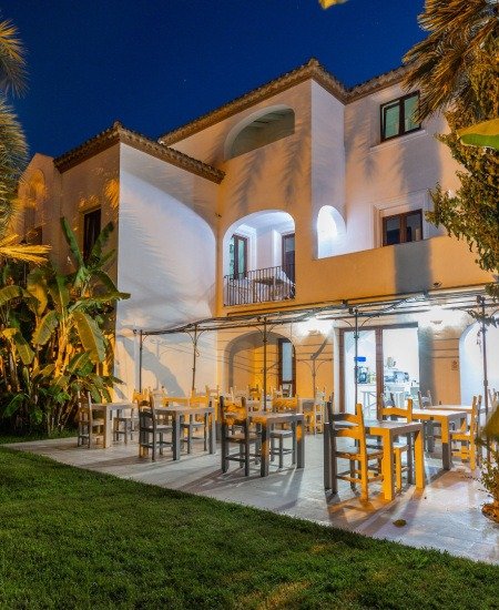 Edificio bianco con terrazza all'aperto di notte.