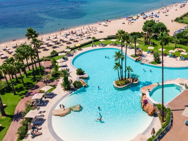 Piscina e spiaggia affollata viste dall'alto.