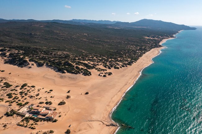 Spiaggia e mare limpido con strutture sulla riva.