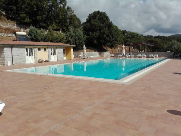 Piscina esterna accanto a un edificio giallo.