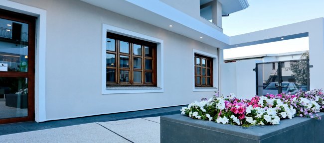 Ingresso di una casa moderna con finestre e fiori.