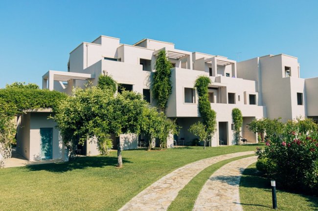 Edificio moderno con giardino curato e alberi.