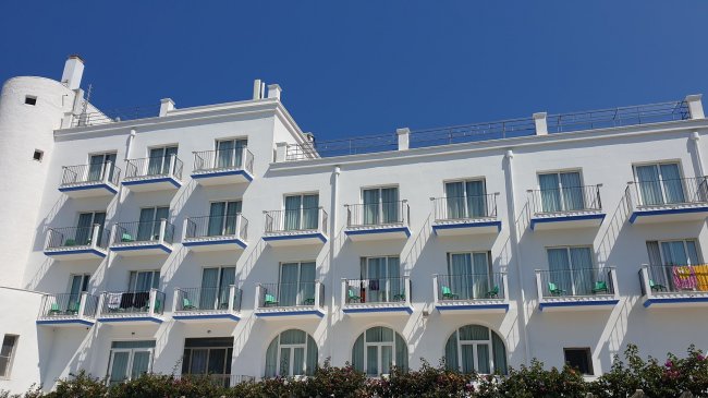 Hotel bianco con balconi e finestre.