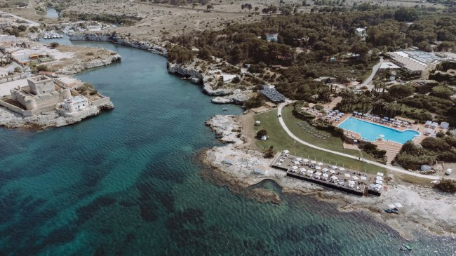 Vista aerea di costa con mare e piscine.