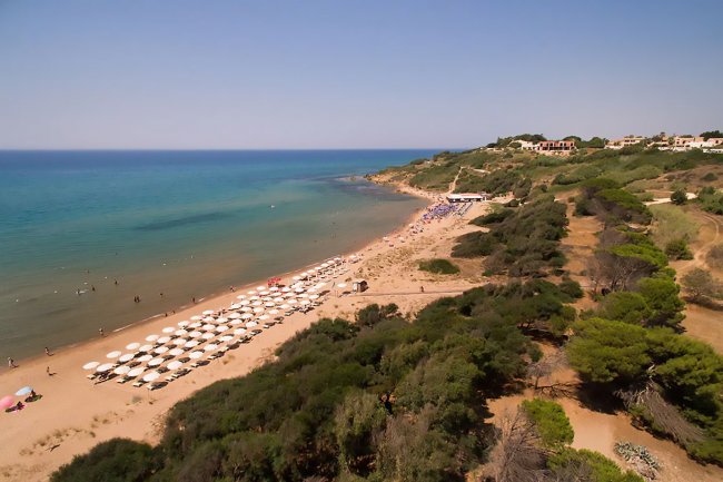 Spiaggia con ombrelloni e mare blu.