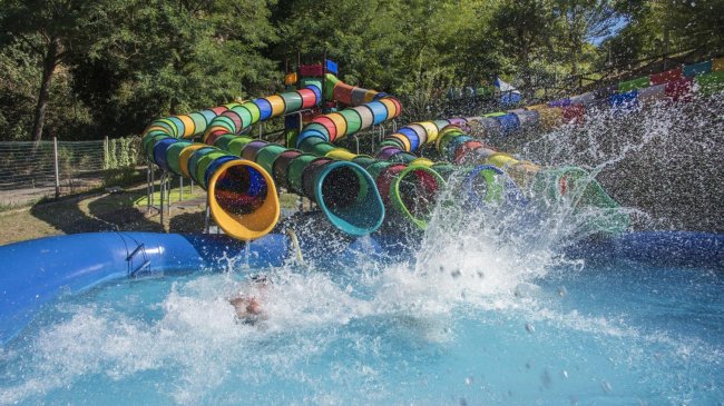 Scivoli d'acqua colorati che terminano in una piscina con grandi schizzi.