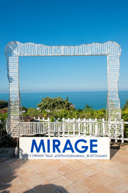 Cornice gigante con vista sul mare e vegetazione.