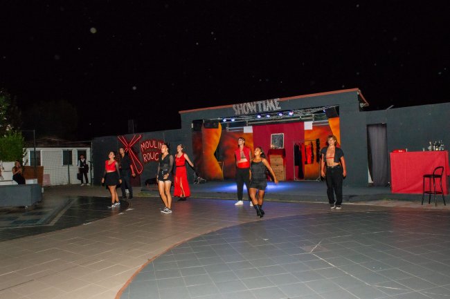Persone ballano su un palco all'aperto di notte.