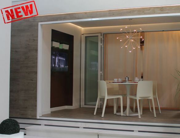 Sala da pranzo con tavolo rotondo e sedie bianche, e lampada moderna.