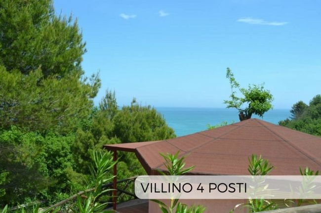 Vista mare con tetto di un gazebo e pini.