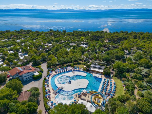 Vista aerea di una piscina con scivoli vicino al mare.