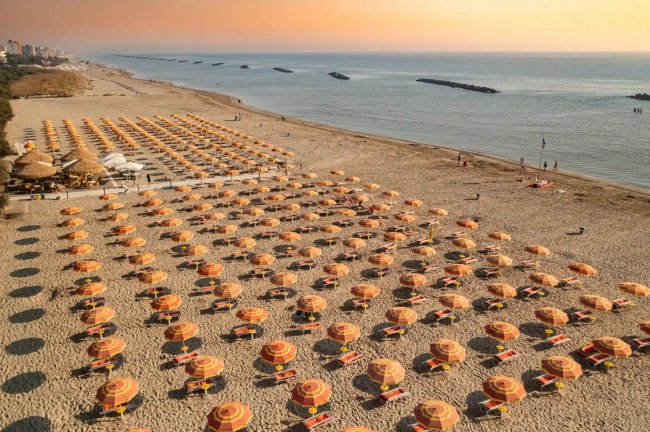 Spiaggia con ombrelloni arancioni.