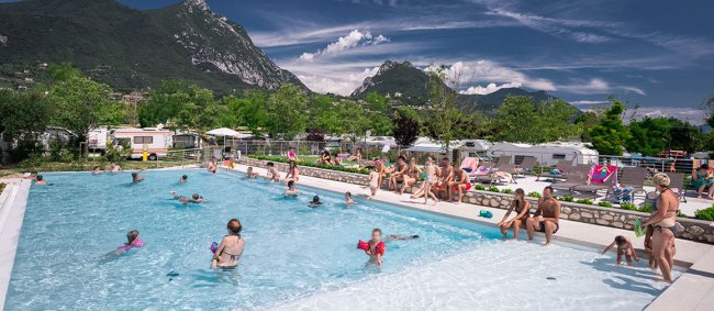 Persone che nuotano in piscina all'aperto.