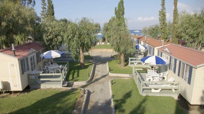 Bungalow con tavolini e ombrelloni, vista mare.