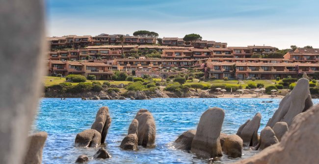 Case su colline vicino al mare e scogli.