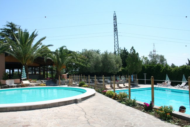 Due piscine all'aperto circondate da palme e sedie a sdraio.