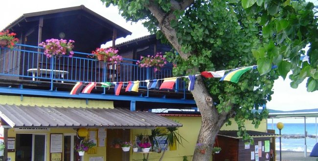 Edificio con balcone pieno di fiori e festoni colorati.