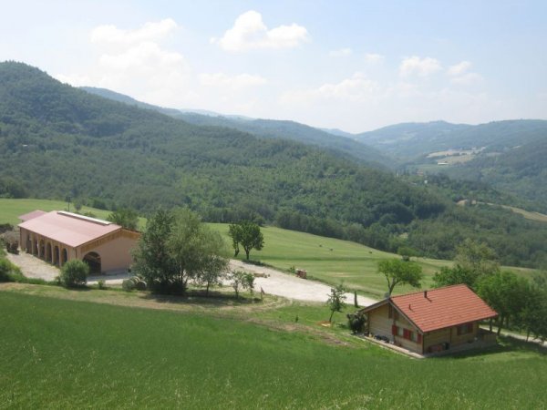 Vista su colline verdi con edifici rurali.