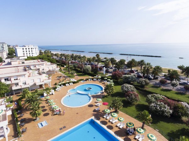 Complesso turistico con piscine e vista mare.