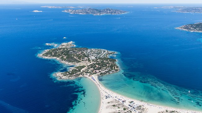 Isola verde con spiaggia sabbiosa e mare blu.