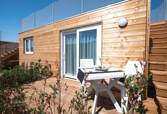 Bungalow in legno con terrazza esterna.