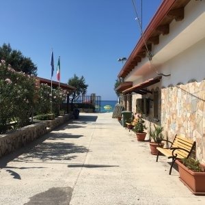Viale con panchina e vista sul mare.
