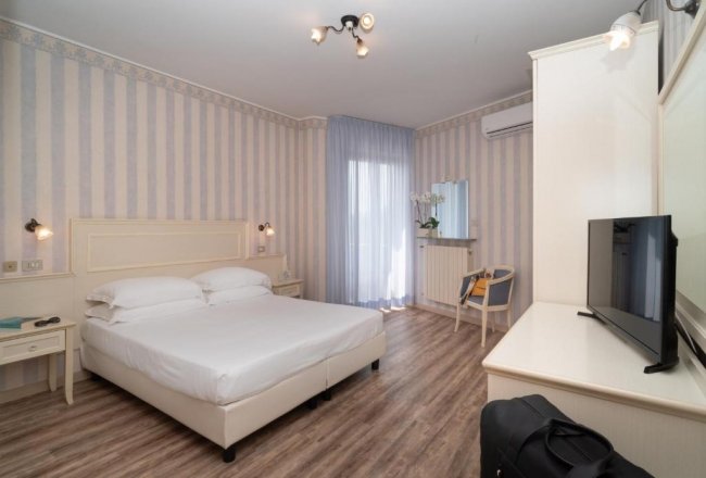 Camera d'hotel con letto matrimoniale e TV.