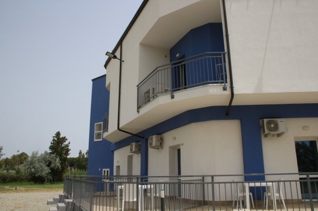 Dettaglio di balconi su un edificio blu e bianco.