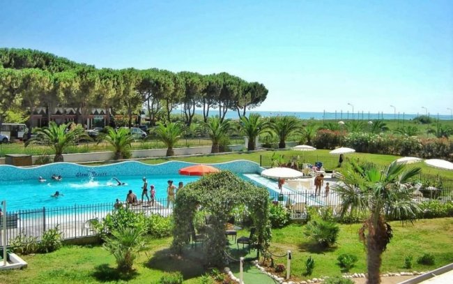 Vista di un hotel con piscina e giardino verde.