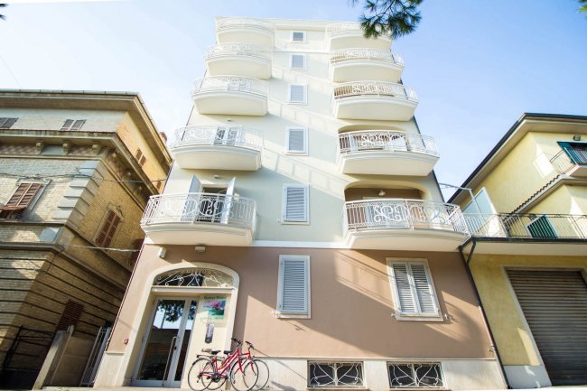 Edificio con balconi e due biciclette fuori.