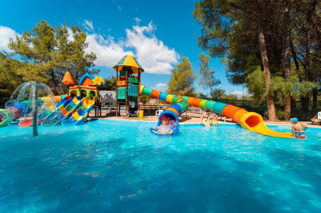 Piscina con scivoli colorati e giochi acquatici.
