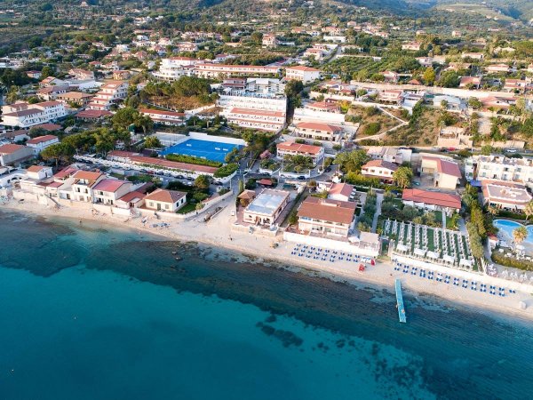 Vista aerea di un villaggio costiero con spiaggia e mare.
