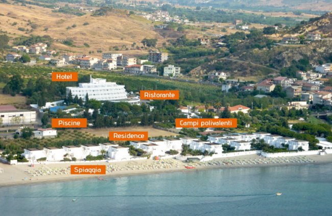 Vista aerea di un resort con hotel, ristorante, piscine e spiaggia.