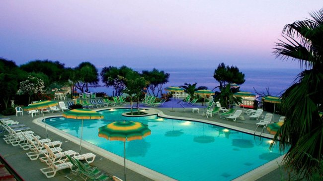 Piscina con vista sul mare al tramonto.