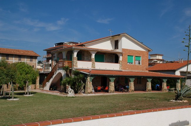 Casa a due piani con portico e terrazza.