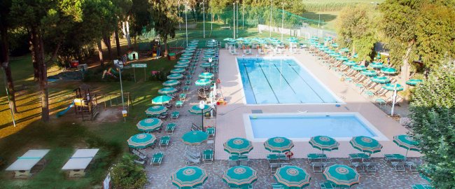 Piscina all'aperto con ombrelloni verdi.