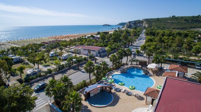 Vista aerea di un resort con piscina e spiaggia.
