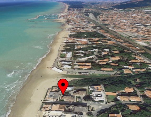 Vista aerea di una costa con spiaggia e case.