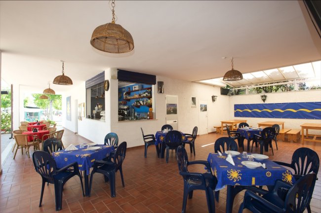 Ristorante con tavoli all'aperto e sedie di plastica.