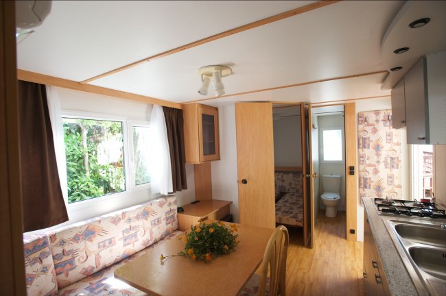 Interno di una casa mobile con cucina e zona pranzo.
