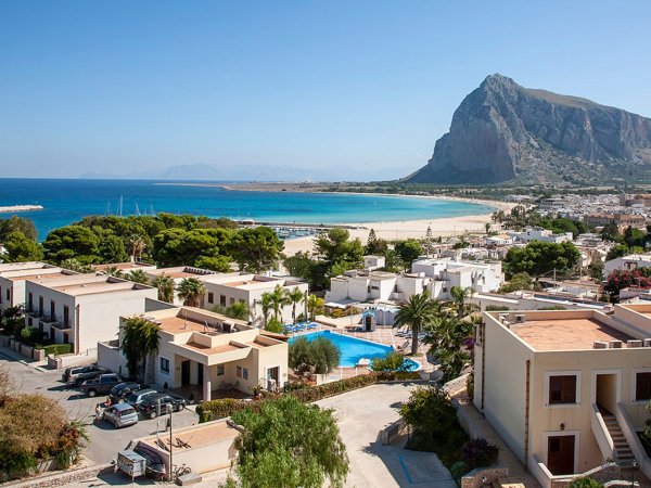 Vista panoramica su spiaggia, mare e montagne.