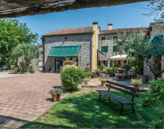 Cortile con panchina e fiori, case in pietra.