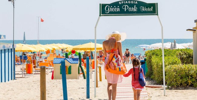 Ingresso sulla spiaggia con ombrelloni gialli.