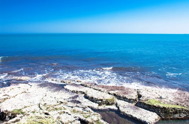 Scogliera e mare azzurro.