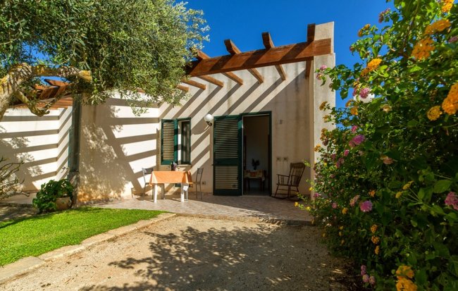 Casa con pergola in giardino soleggiato.